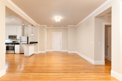 A kitchen with white cabinets and a black countertop.