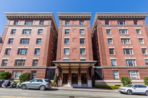 A red brick building with a car parked in front.