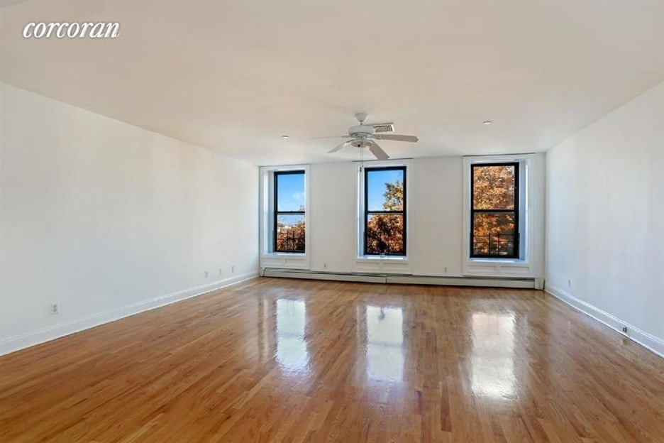 A room with wooden floors and a ceiling fan.