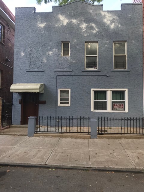 a blue building with a fence in front of it
