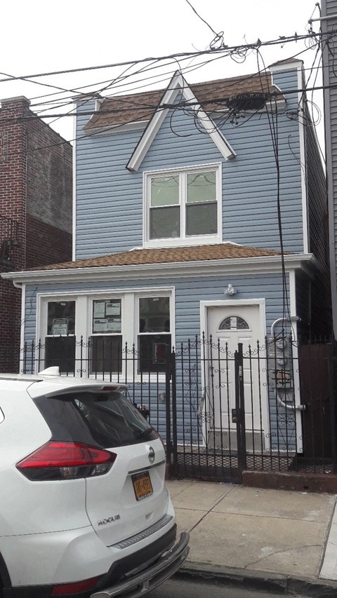a blue house with a white car parked in front of it