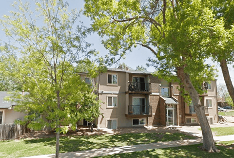 an apartment building with trees in front of it