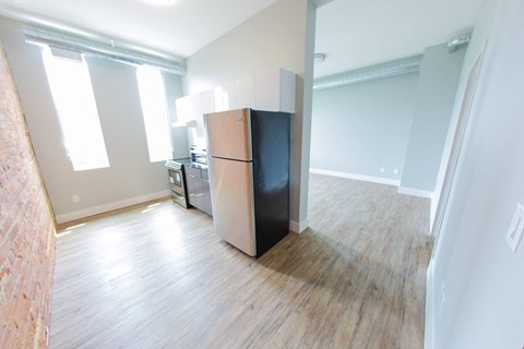 an empty room with a refrigerator in the middle