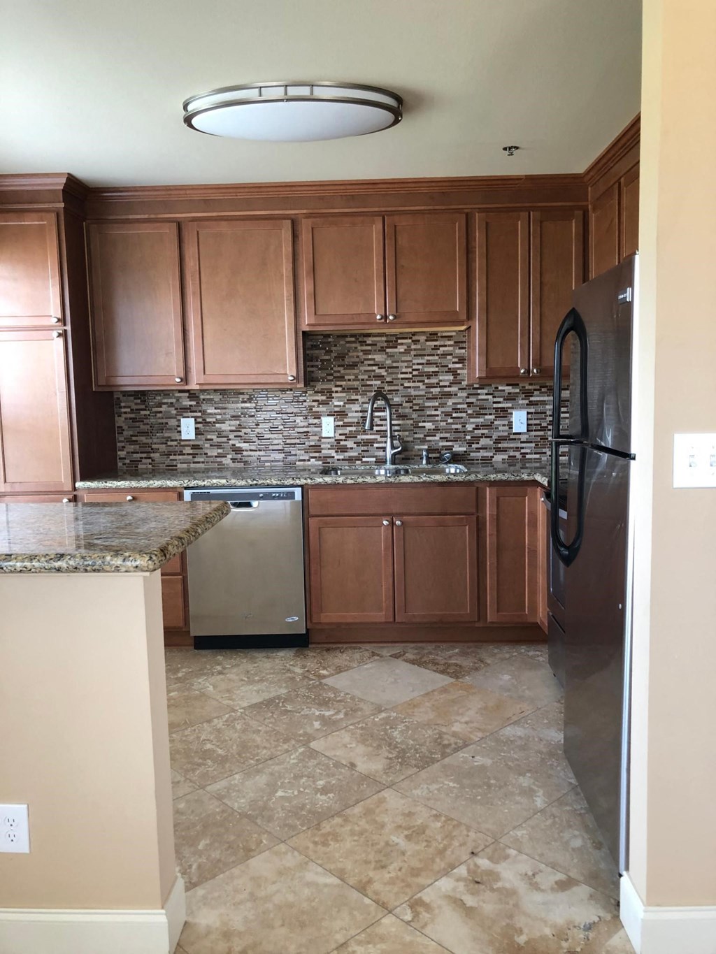 a kitchen with wooden cabinets and stainless steel appliances
