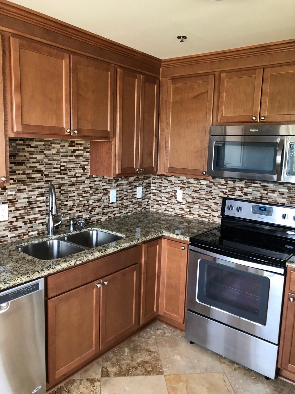a kitchen with wood cabinets and stainless steel appliances