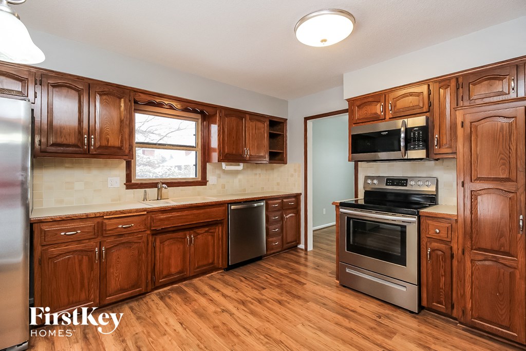 a kitchen with wooden cabinets and stainless steel appliances