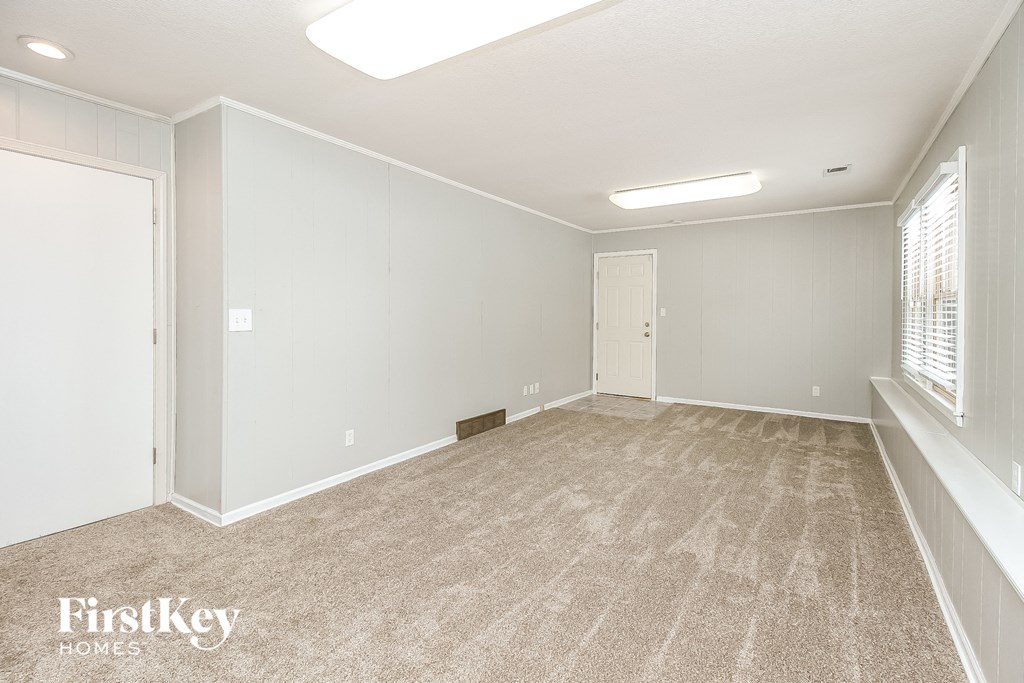the living room of a new home with white walls and carpet
