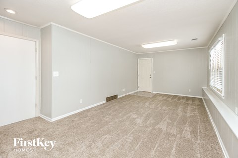 the living room of a new home with white walls and carpet