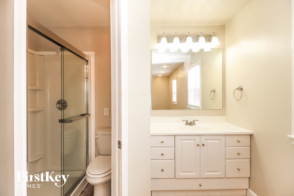 a bathroom with a shower and a sink and a mirror