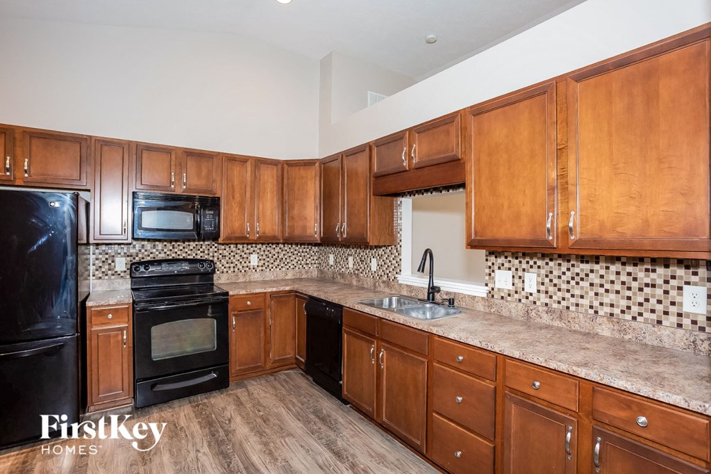 a kitchen with wooden cabinets and black appliances
