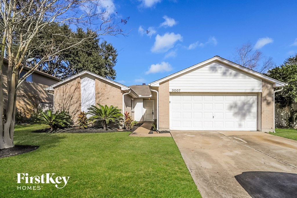 a home with a white garage door and a lawn