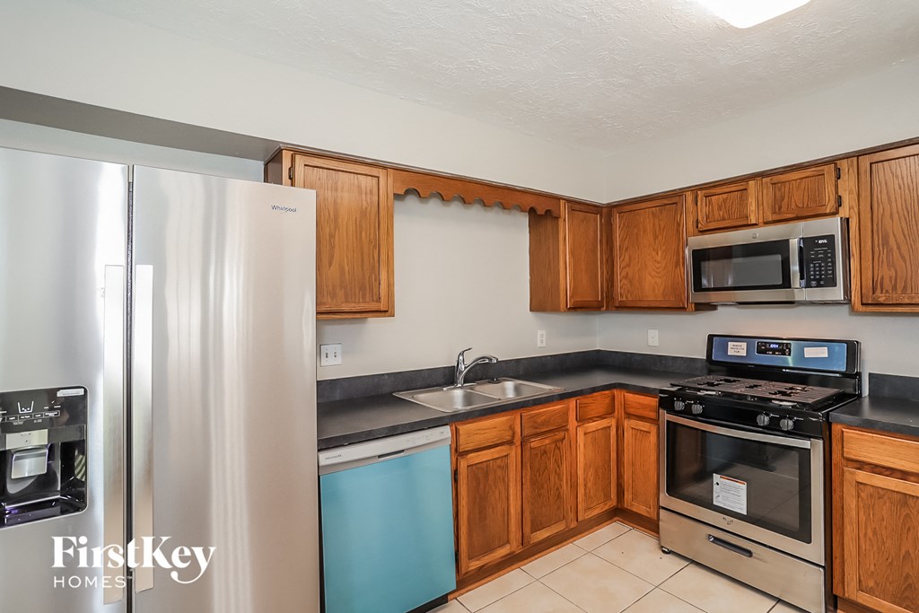 a kitchen with wooden cabinets and stainless steel appliances