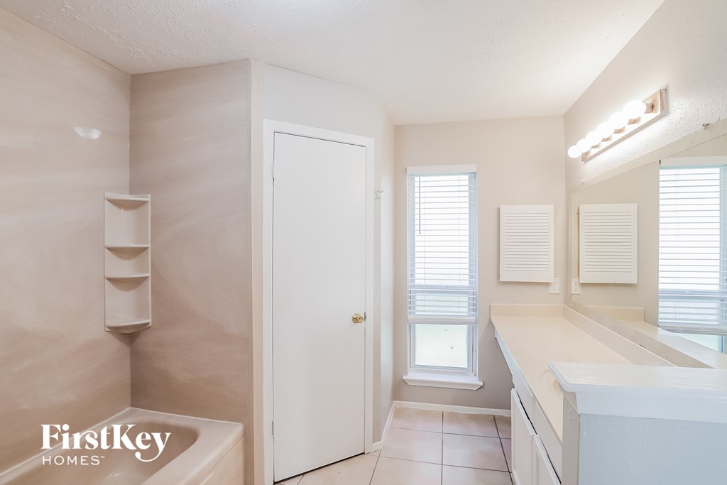 a bathroom with a tub and a sink and a mirror