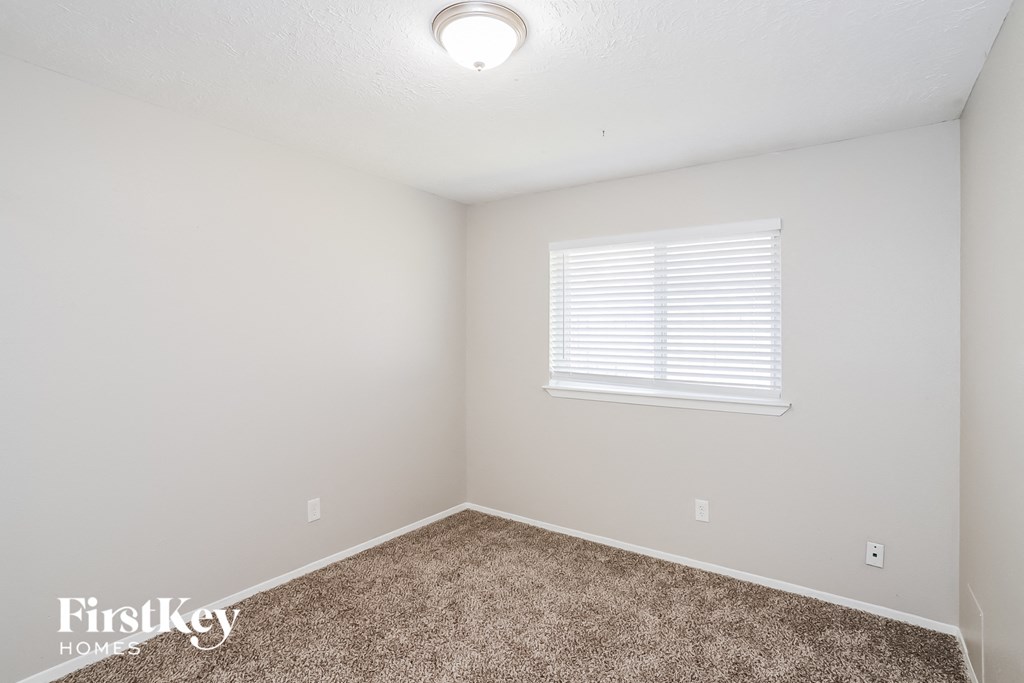 a bedroom with a carpeted floor and a window