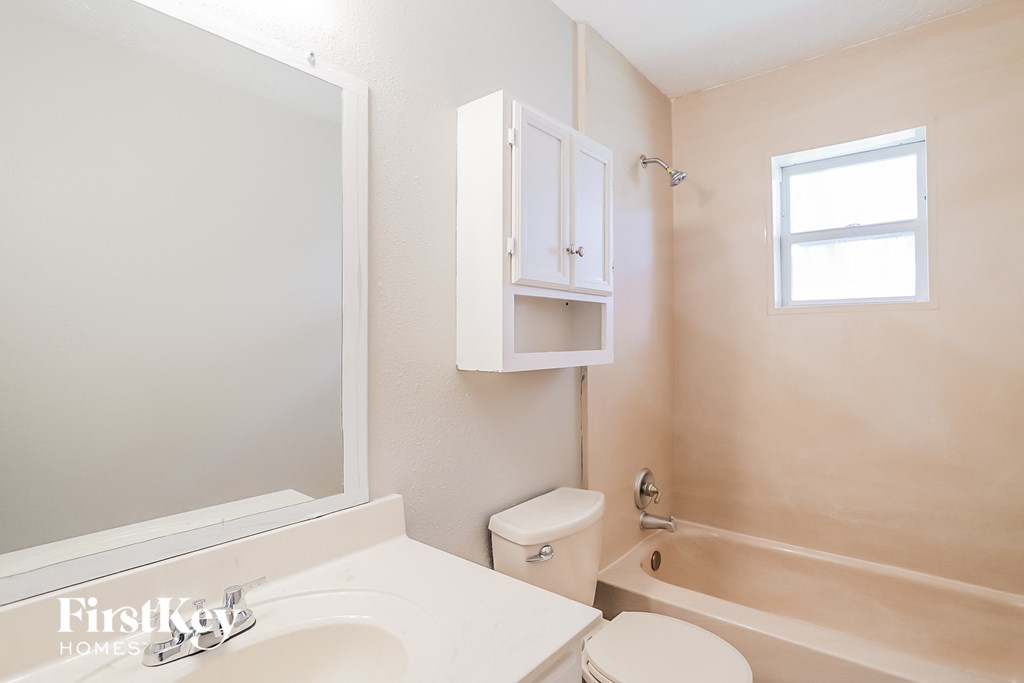 a bathroom with a white sink and toilet and a bath tub