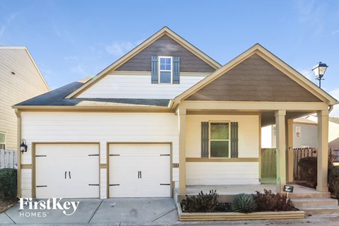 the front exterior of a home with white garage doors