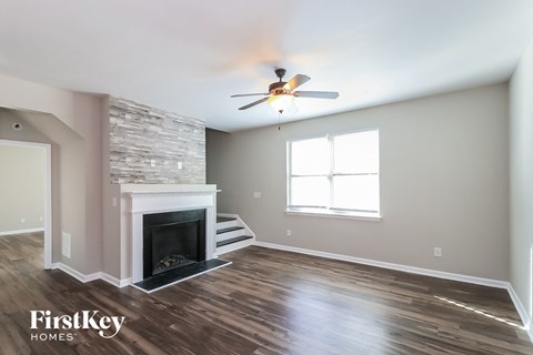 a living room with a fireplace and a ceiling fan