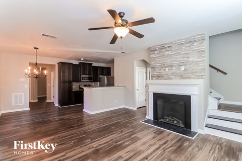 a living room with a fireplace and a kitchen