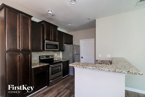 a kitchen with dark wood cabinets and granite counter tops