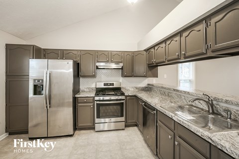 a kitchen with stainless steel appliances and marble counter tops