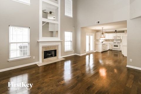 A spacious living room with wood floors and a fireplace.