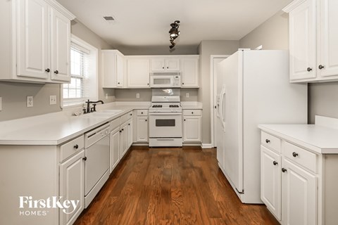 A kitchen with white cabinets and appliances.