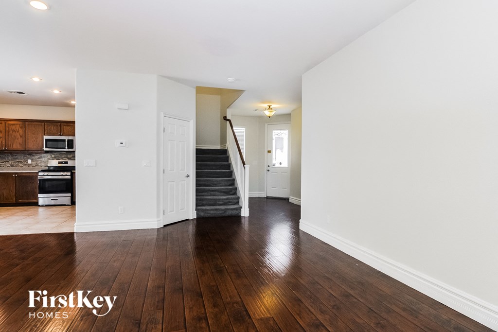 A spacious room with wooden floors and white walls.