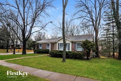 a small brick house with a sidewalk in front of it