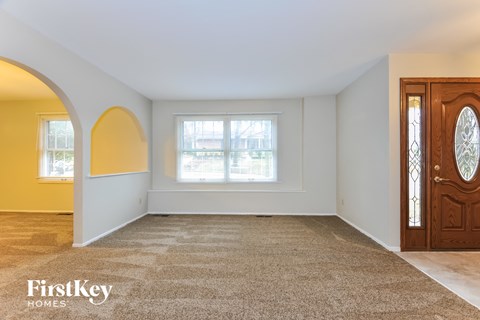 an empty living room with a door and a window