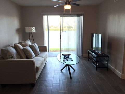 A living room with a couch, a coffee table, and a television.