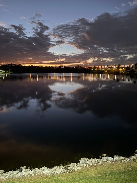 A serene lake reflects the evening sky at dusk.