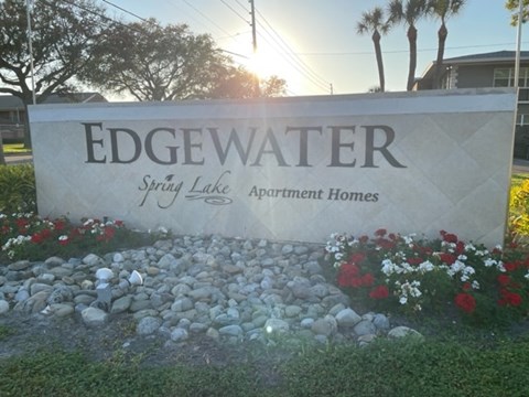 A sign for Edgewater Spring Lake Apartment Homes is shown in front of a building.