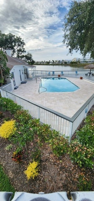 A pool surrounded by a fence and some bushes.