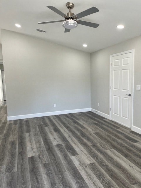 an empty living room with wood floors and a ceiling fan