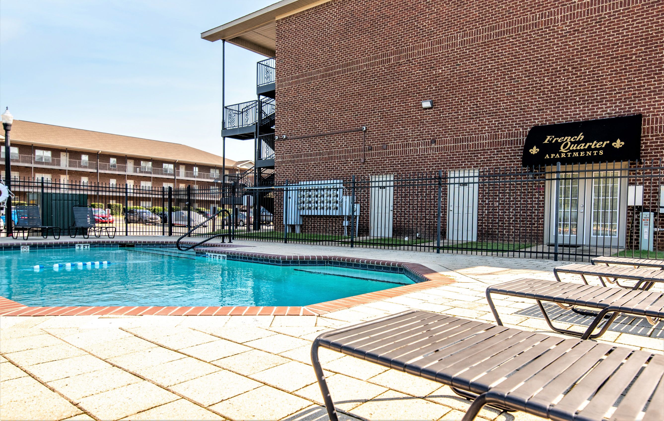 a swimming pool in front of a brick building