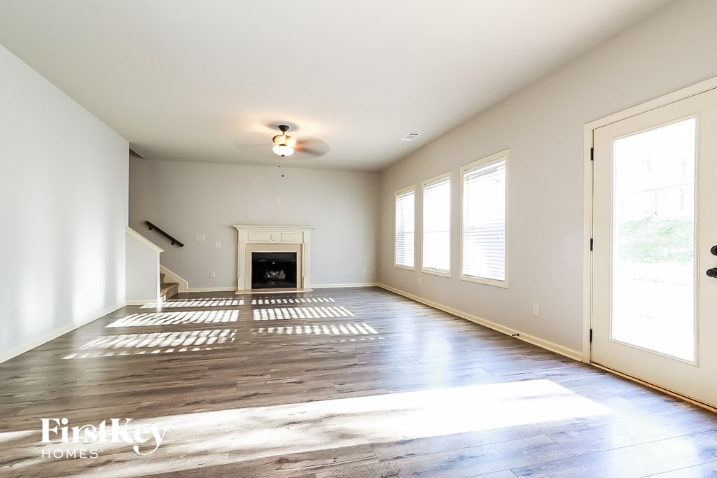 an empty living room with white walls and a fireplace