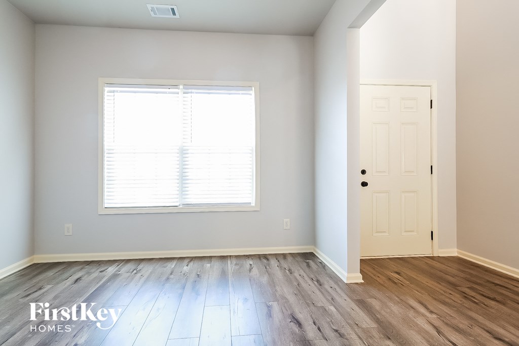 a renovated living room with wood floors and a white door