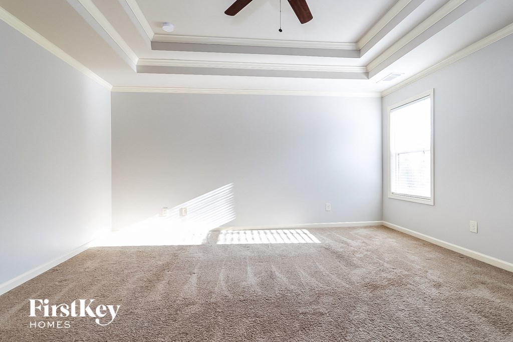 an empty living room with carpet and a ceiling fan