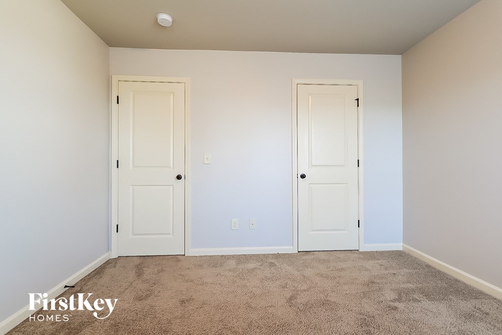 a room with two white doors and a carpeted floor