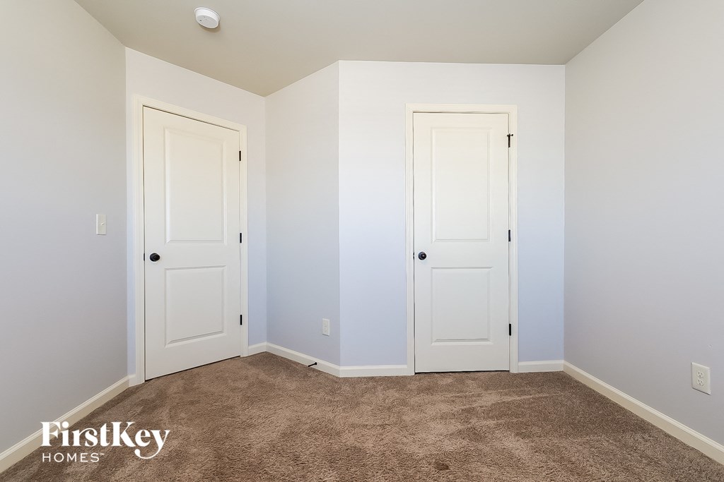 a bedroom with two white doors and a carpeted floor