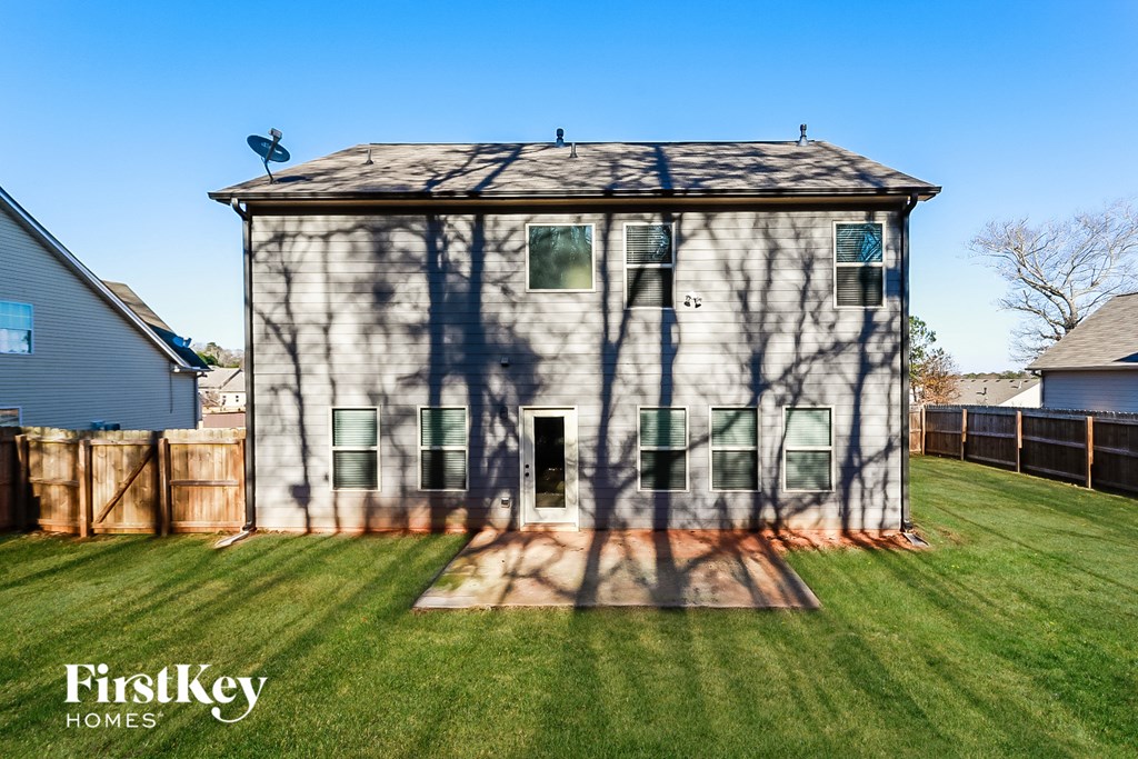 the backyard of a house with a shed and a fence