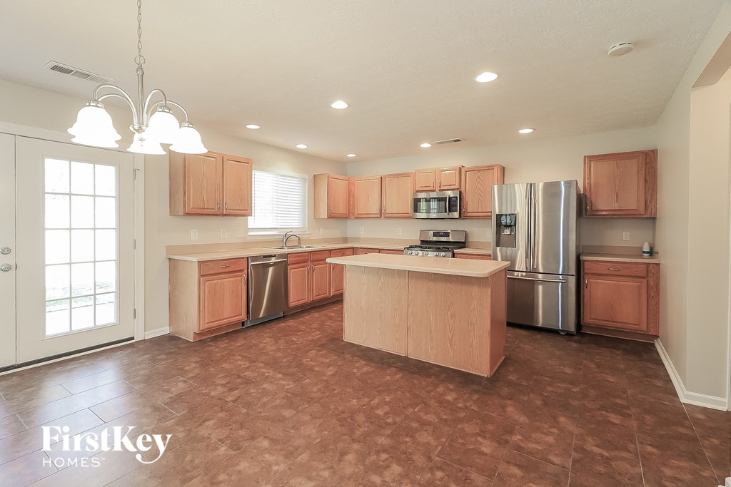a kitchen with wooden cabinets and stainless steel appliances