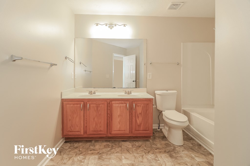 a bathroom with a sink toilet and a mirror