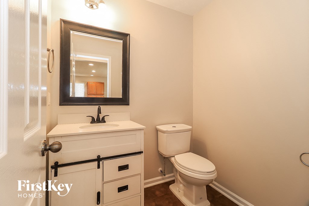 a bathroom with a sink toilet and a mirror