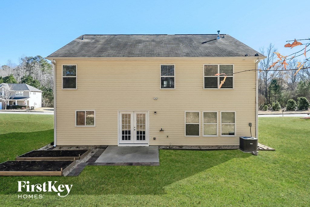 the back of a house with a ramp to the yard