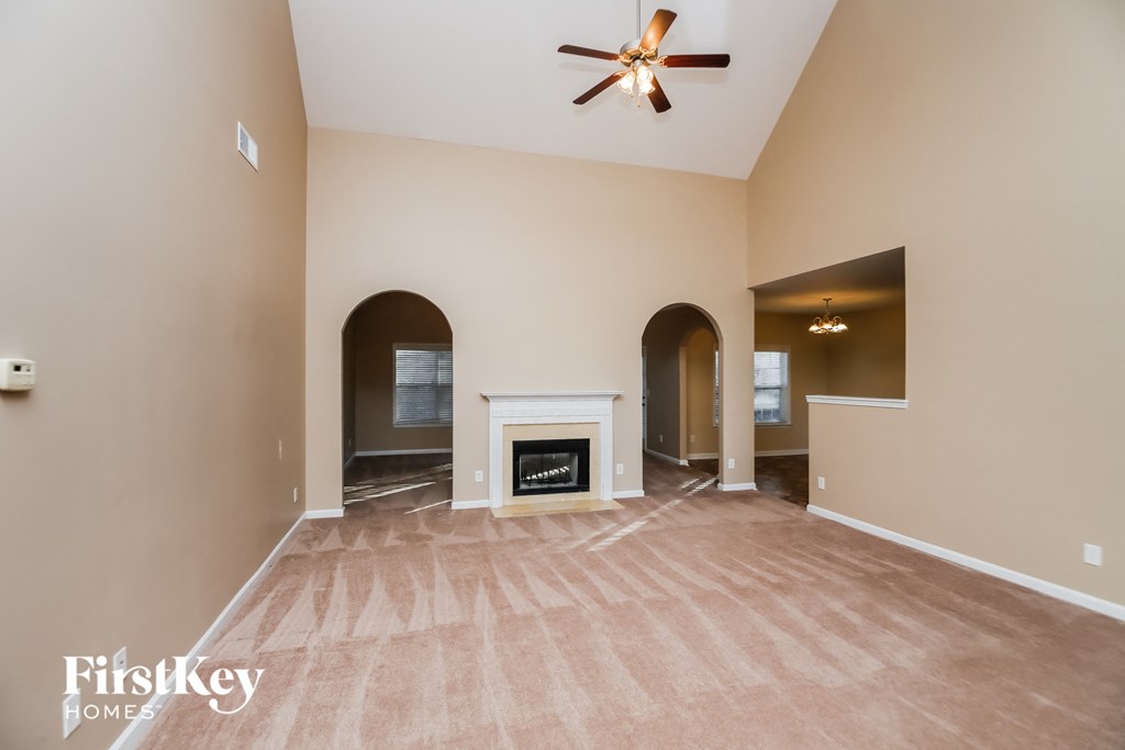 A spacious room with a fireplace and a ceiling fan.