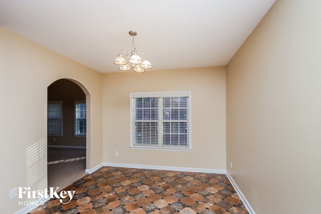 A room with a tiled floor and a window with blinds.