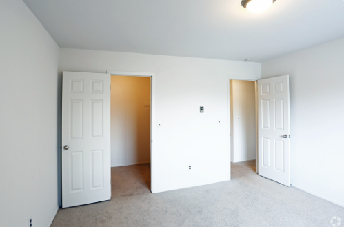 an empty room with two white doors in it