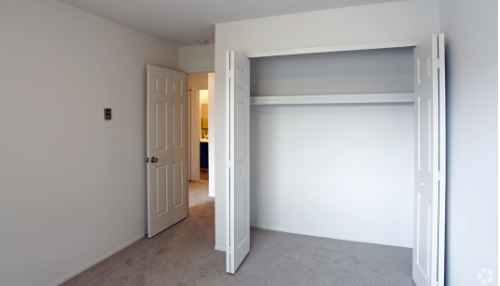 an empty bedroom with an open closet door
