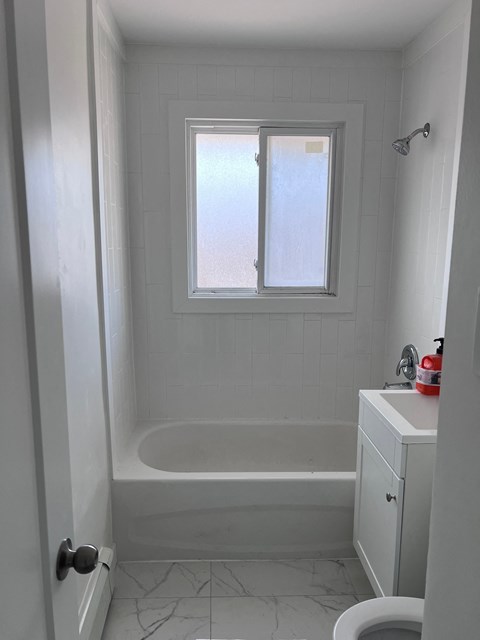 a small bathroom with a tub and a window